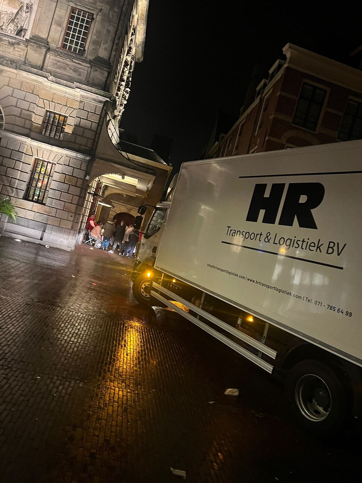 Bakwagen van HR Transport & Logistiek bij een avondlevering in de binnenstad