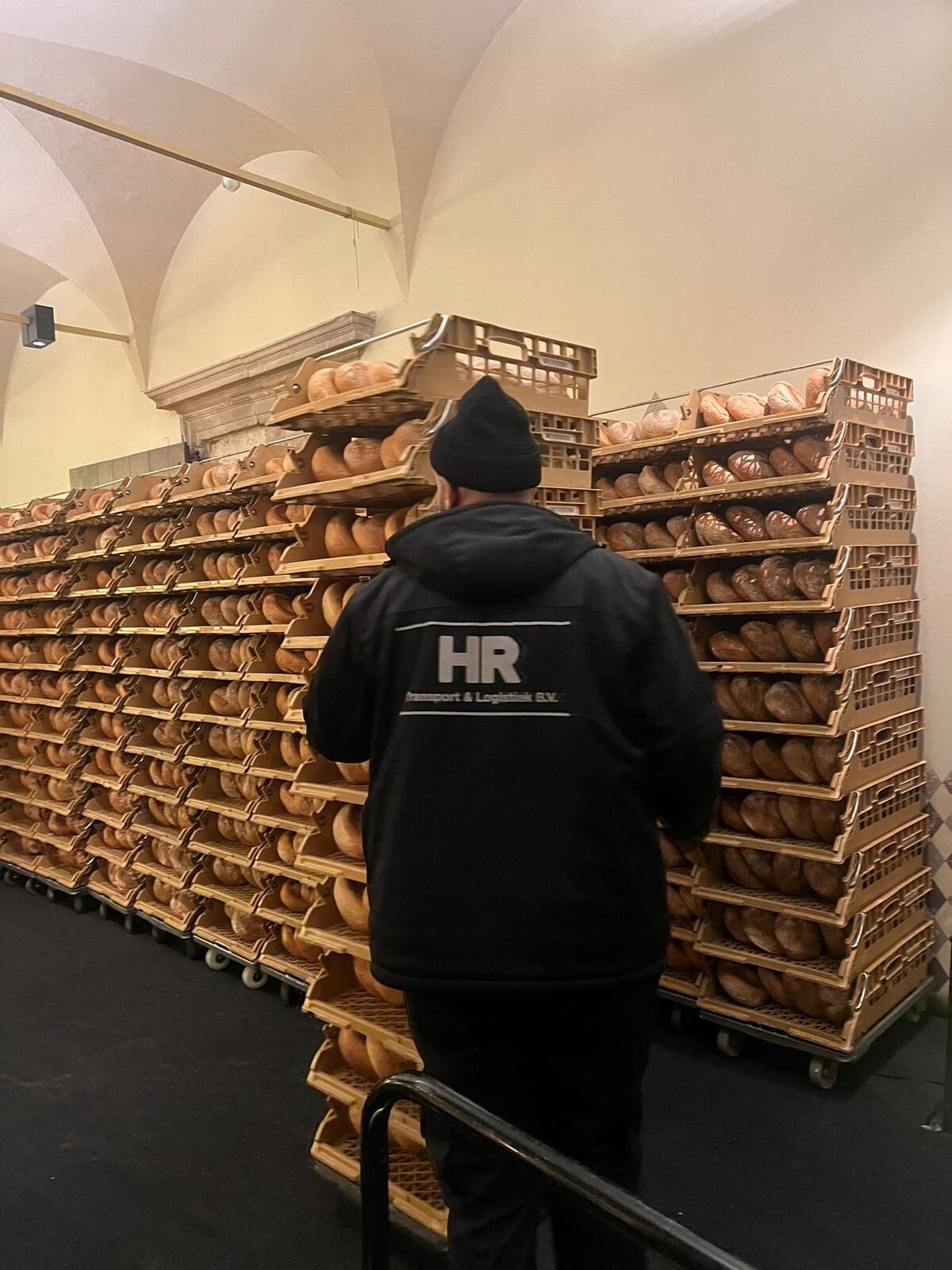 Medewerker van HR Transport & Logistiek bij kratten met brood
